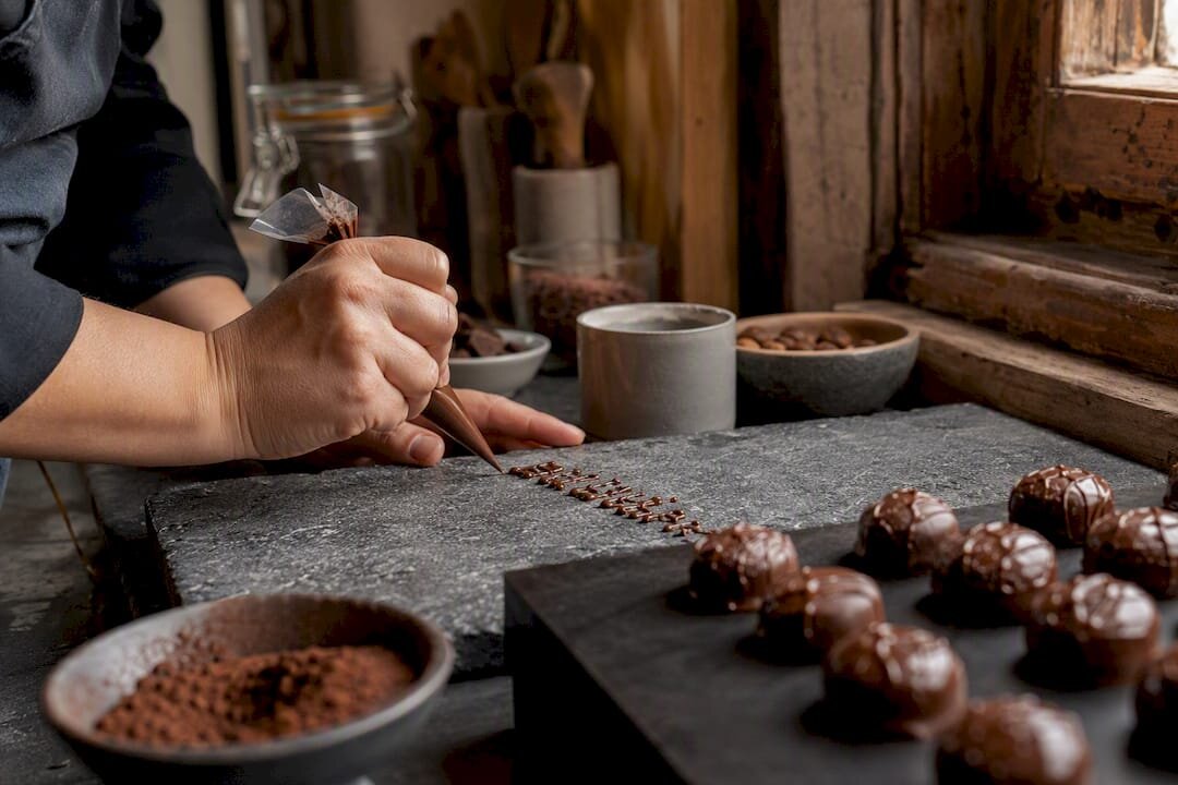 Handen die gepersonaliseerde chocoladeletters spuiten